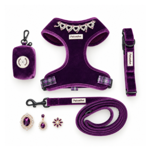 Flat lay of the purple velvet dog set: harness, collar, leash, poop bag dispenser and three amethyst charms