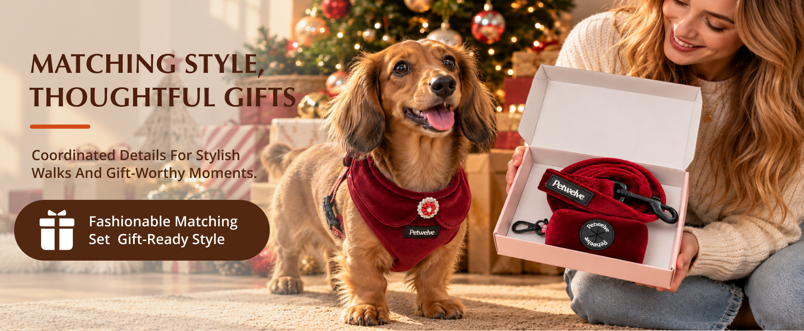 Woman opening a pink Petwelve gift box with the burgundy harness set, a dachshund beside her by a Christmas tree